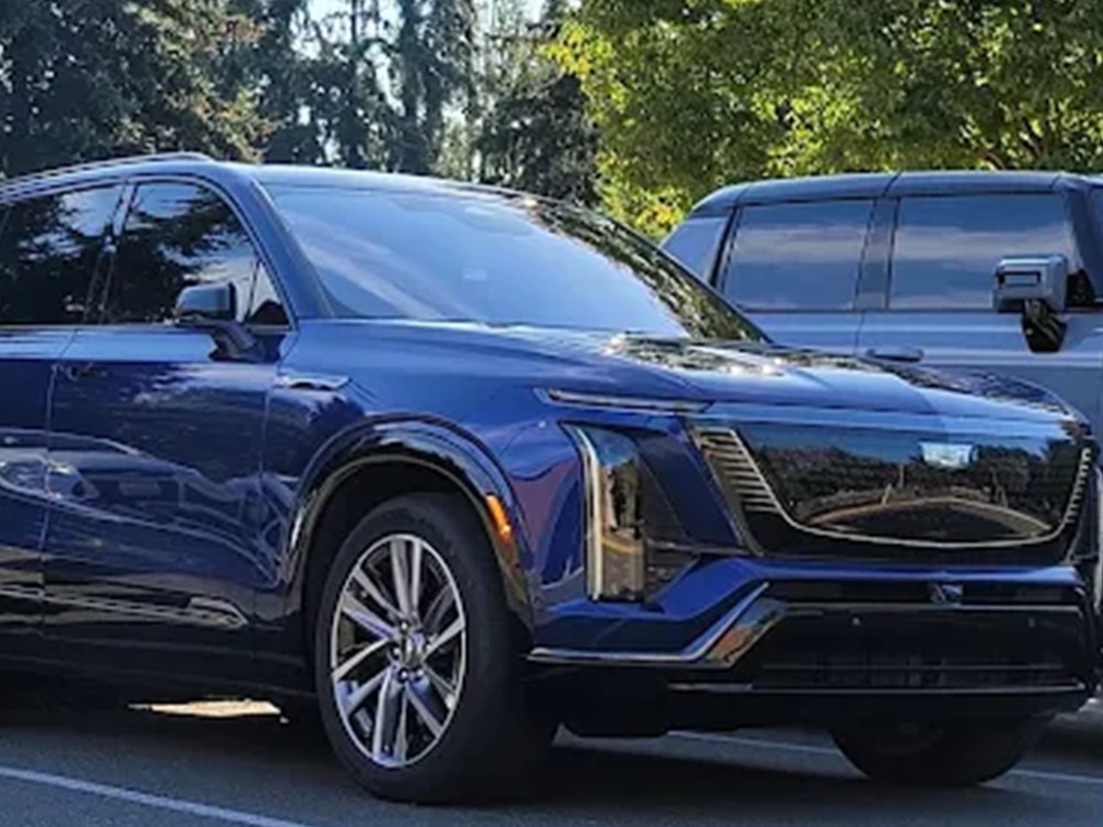 The same Cadillac electric SUV after repair, front left corner refinished and reassembled